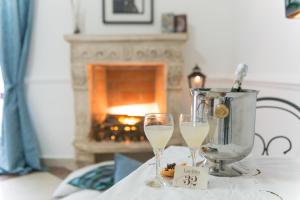 two glasses of white wine sitting on a table with a blender at Camera Ardea con Camino in Aversa +26 photos
