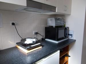a kitchen with a microwave and a toaster on a counter at Costa Plenti Southend BnB in Southend