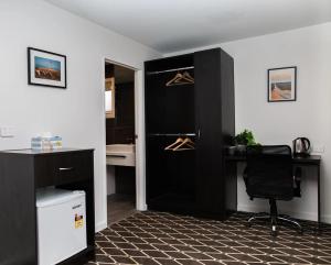 Zimmer mit einem schwarzen Schrank mit einem Schreibtisch und einem Stuhl in der Unterkunft ODYSSEY APOLLO BAY in Apollo Bay