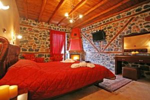 a bedroom with a red bed and a fireplace at Patriko Mountain Chalet in Palaios Agios Athanasios