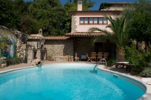 a swimming pool in front of a house at Palazzo Conforti Tree House Resort in Marano Marchesato