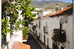 an alley with white buildings and a tree at La Villa Marbella - Old Town in Marbella