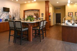 a large kitchen with a bar with chairs around it at Staybridge Suites Merrillville, an IHG Hotel in Merrillville