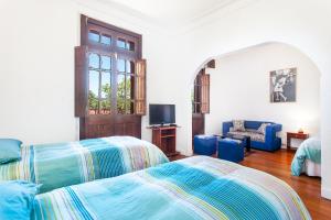a bedroom with a bed and a couch and a tv at Italia Suite in Santiago