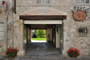 un arco en un edificio de piedra con flores en La Locanda Del Grop, en Tavagnacco