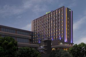 un bâtiment d'hôtel éclairé avec ses lumières allumées dans l'établissement Holiday Inn Express Gurugram Sector 50, an IHG Hotel, à Gurgaon