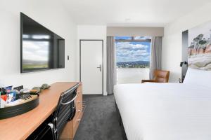 ein Hotelzimmer mit einem großen Bett und einem Schreibtisch in der Unterkunft Hotel Launceston in Launceston