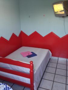 ein rotes Schlafzimmer mit einem Bett mit rotem Kopfteil in der Unterkunft Hotel Spada in Belém
