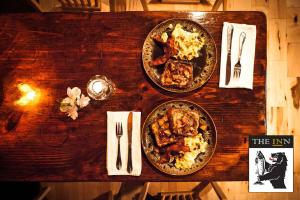 a wooden table with two plates of food on it at The INN in Montgomery