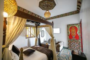 a bedroom with a canopy bed and a couch at Palais Houyam in Fès