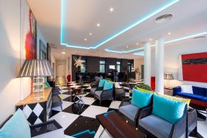- un salon avec des chaises bleues et un hall dans l'établissement Holiday Inn Express Lisboa - Av. Liberdade, an IHG Hotel, à Lisbonne