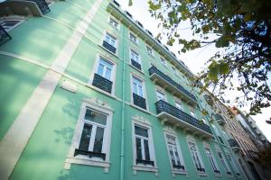 een groen gebouw met witte ramen aan de zijkant bij Holiday Inn Express Lisboa - Av. Liberdade, an IHG Hotel in Lissabon