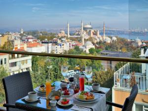 a table with food and drinks on a balcony with a view at Burckin Hotel in Istanbul