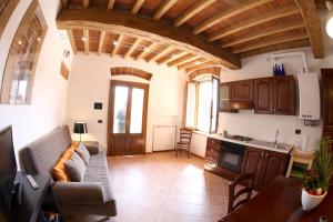 ein Wohnzimmer mit Sofa und eine Küche in der Unterkunft B&B Stradivari in Cremona