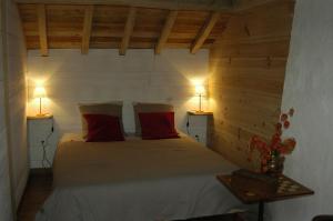 ein Schlafzimmer mit einem Bett mit zwei Lampen an zwei Tischen in der Unterkunft Chambres d'Hotes Au Vieux Logis in Nistos
