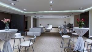 a room with white chairs and tables and flowers at Holiday Inn Express Culiacan by IHG in Culiacán