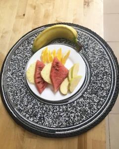 a plate with fruit and a banana on a table at Harmony Resort Boutique Hotel in Bathurst