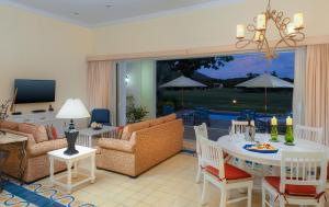 sala de estar con mesa, sillas y TV en Pueblo Bonito Emerald Bay Resort & Spa - All Inclusive, en Mazatlán