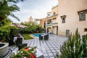 un patio con mesas y sillas y una piscina en Palais Houyam en Fez