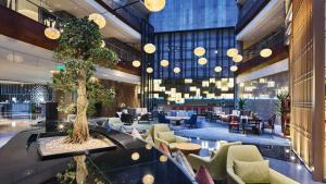 a hotel lobby with a tree in the middle at Holiday Inn Xining Hot-Spring, an IHG Hotel in Xining