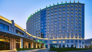 a large blue hotel building with a street in front of it at Holiday Inn Xining Hot-Spring by IHG in Xining