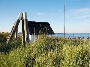 a building on a beach with tall grass at Casa Strandperle in Scharbeutz