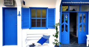 een blauwe deur en ramen op een wit gebouw bij Pousada Costa Verde in Abraão