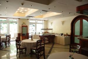 a restaurant with tables and chairs and a kitchen at Hotel Villa Vera in Lovran