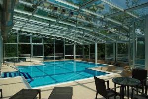 a swimming pool in a house with a glass ceiling at Hotel Villa Vera in Lovran