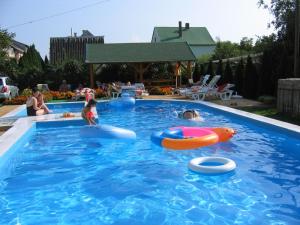 a group of people playing in a swimming pool at Bor Apartmanház in Gyenesdiás