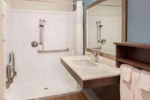 a white bathroom with a sink and a shower at Wood Spring Suites Washington DC East Arena Drive in Hyattsville +19 photos