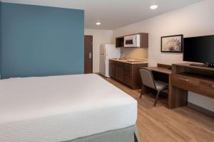 a hotel room with a bed and a desk and a kitchen at Wood Spring Suites Washington DC East Arena Drive in Hyattsville