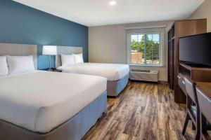 A bed or beds in a room at WoodSpring Suites Baltimore White Marsh - Nottingham