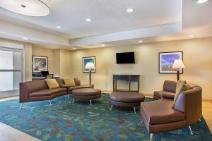 a waiting room with couches and chairs and a fireplace at Candlewood Suites Fort Campbell - Oak Grove by IHG in Oak Grove