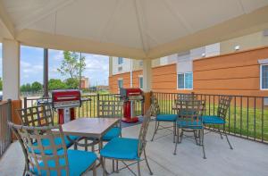 eine Terrasse mit einem Tisch, Stühlen und einem Grill in der Unterkunft Candlewood Suites Fort Campbell - Oak Grove, an IHG Hotel in Oak Grove