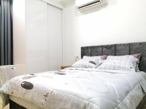 ein Schlafzimmer mit einem großen Bett mit einer weißen Bettdecke in der Unterkunft REVO at AURORA PLACE, Pavilion 2, 5 Minutes To AXIATA ARENA BUKIT JALIL FREE WIFI by De Harlequins Guesthouse in Kuala Lumpur