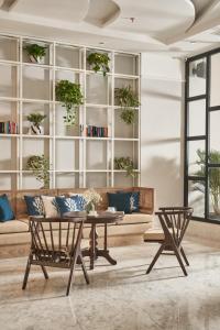 a living room with a couch and a table at Sofiana My Khe Hotel & Spa- Rooftop Pool Bar in Danang