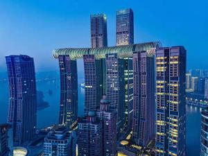 a group of tall buildings in a city at night at Ascott Raffles City Chongqing in Chongqing