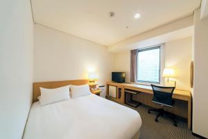 Cette chambre comprend un lit et un bureau avec un ordinateur. dans l'établissement Hotel Granvia Osaka-JR Hotel Group, à Osaka
