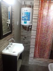 a bathroom with a sink and a shower curtain at Las casitas de Mar in Mar de Ajó