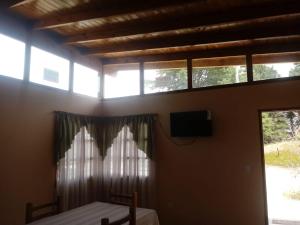 a bedroom with a bed and a tv and windows at Las casitas de Mar in Mar de Ajó