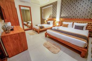 um quarto de hotel com uma cama grande e um sofá em Rivora Residence em Kandy