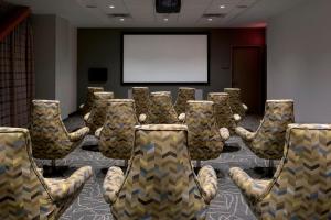 a group of chairs in a room with a screen at EVEN Hotel Pittsburgh Downtown, an IHG Hotel in Pittsburgh