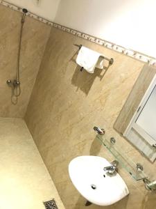bagno con lavandino bianco e specchio di Salyna Motel a Da Nang