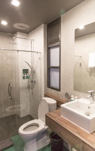 a bathroom with a toilet and a sink and a shower at The Rodman Hotel in Chiang Mai