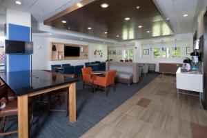 uma sala de espera num hospital com cadeiras e mesas em Holiday Inn Express & Suites La Porte, an IHG Hotel em LaPorte
