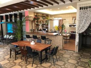 a kitchen and dining room with a wooden table and chairs at 山同青旅Backpacker Hostel in Puli