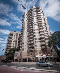 a car driving down a street next to a tall building at Fiori Apartments in Sydney