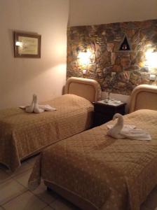 Una habitación de hotel con dos camas con cisnes. en Litsa, en Plomari