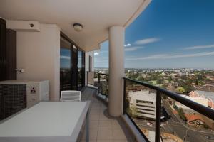 balcón con mesa y vistas a la ciudad en Fiori Apartments, en Sídney